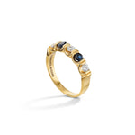 Load image into Gallery viewer, Gold ring with alternating blue and clear gemstones on a white background