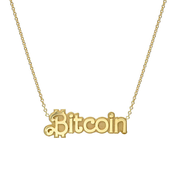 A gold pendant necklace with the word 'Bitcoin' engraved in capital letters, hanging from a rolo link chain.