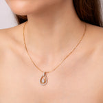 Load image into Gallery viewer, Gold and silver teardrop-shaped pendant on a gold chain against a model neck