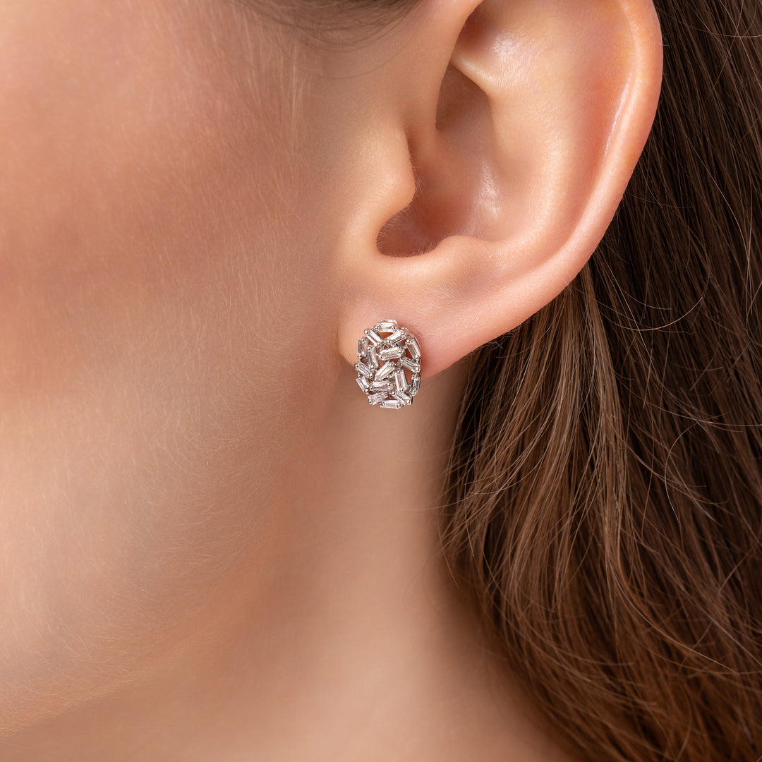 Pair of silver earrings with gemstones on a model ear