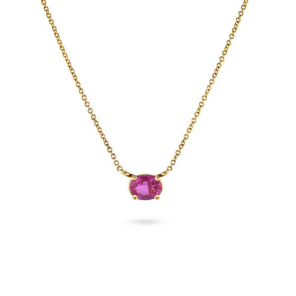 An oval pink sapphire necklace set in yellow gold, suspended on a rolo link chain.