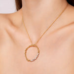 Load image into Gallery viewer, Gold necklace with a circular pendant on a model neck
